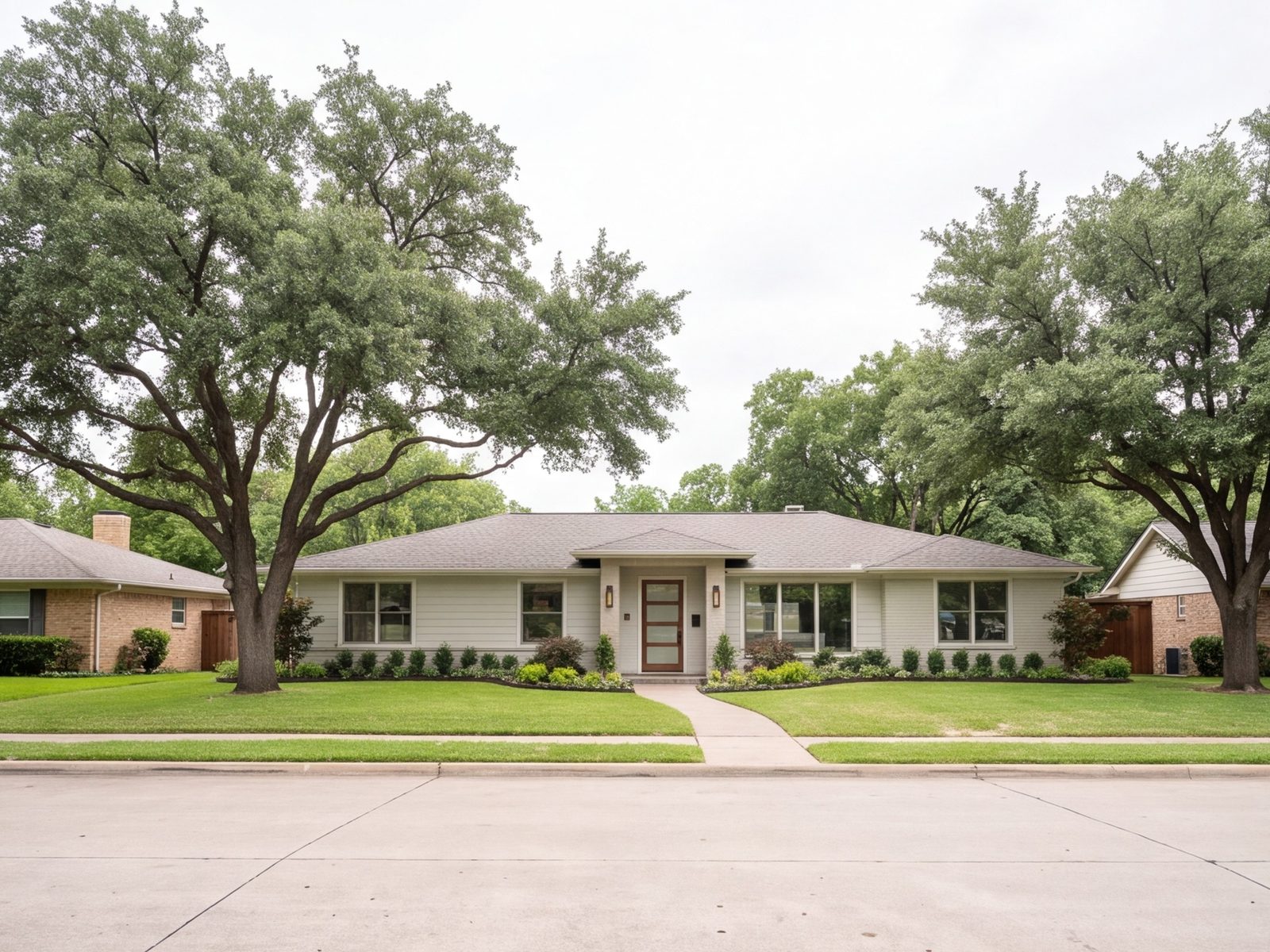 Remodeled 1950s Dallas ranch house with new siding and a modern entry, seen from the street