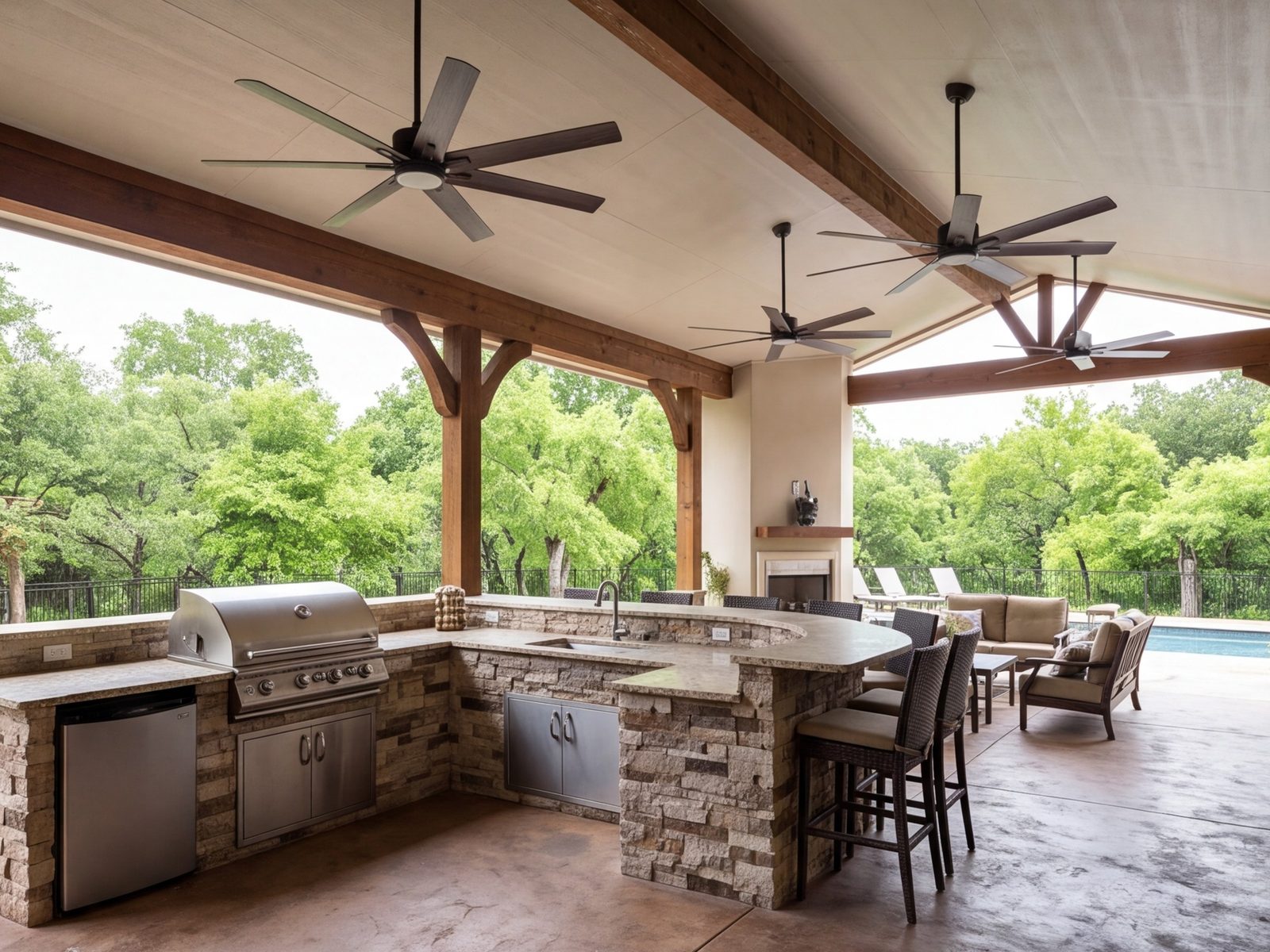 Covered patio with an outdoor kitchen, grill, bar seating and ceiling fans